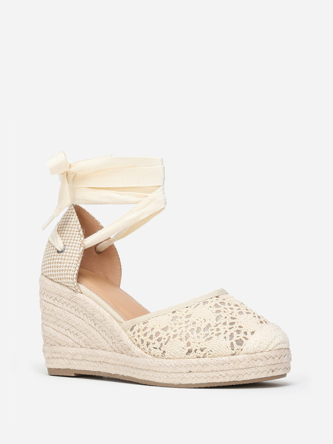 Espadrilles compensées beiges dentelées à nouer sur la jambe