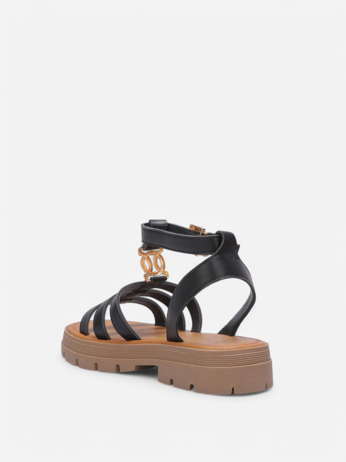 Spartiates crantées noires à monogramme métallique.