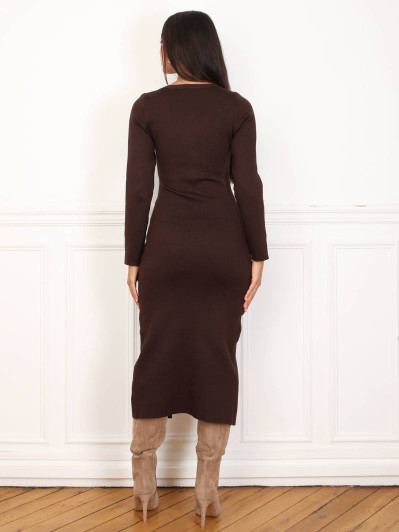 Robe mi-longue marron à boutons et ceinture dorés.