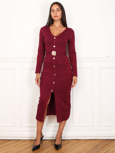 Robe mi-longue bordeaux à boutons et ceinture dorés.
