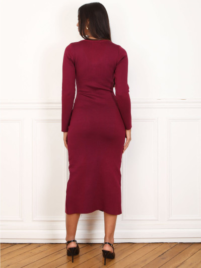 Robe mi-longue bordeaux à boutons et ceinture dorés.